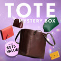 Promotional graphic for a 'Tote Mystery Box' featuring a collection of totes, wallets, and small goods. Set against a purple sparkly background with a pink badge indicating up to $575 value.